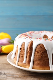 Photo of Glazed Easter cake with sprinkles on wooden table, closeup