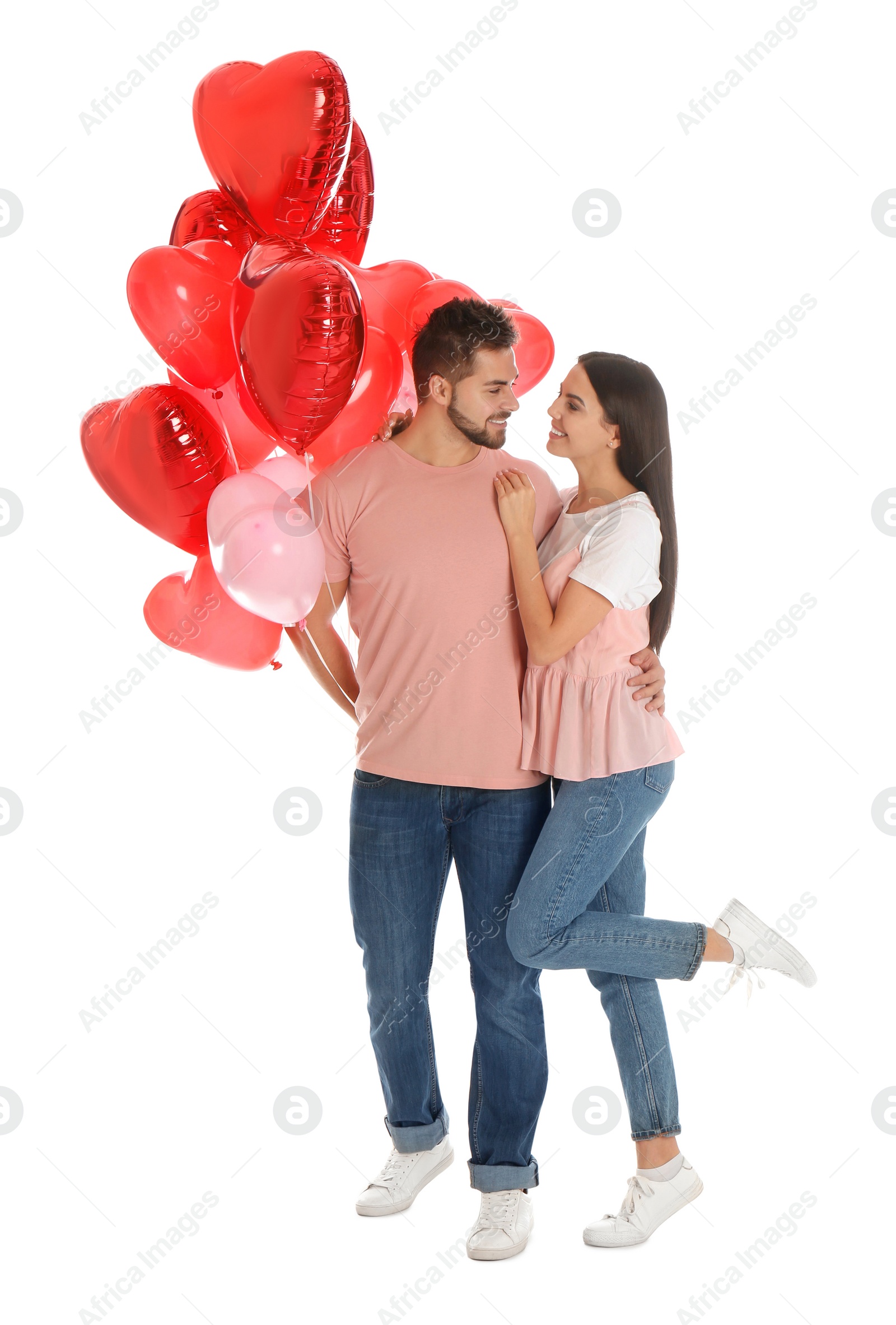 Photo of Happy young couple with heart shaped balloons isolated on white. Valentine's day celebration