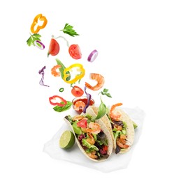 Image of Delicious tacos. Ingredients falling into tortillas on white background