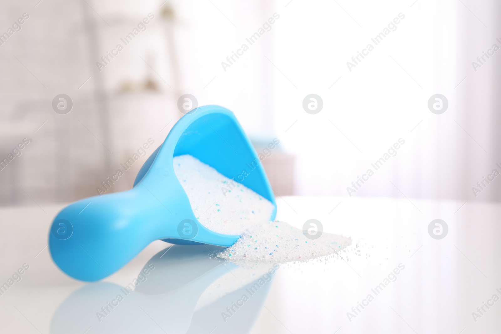 Photo of Scoop with washing powder on table indoors, space for text. Laundry day