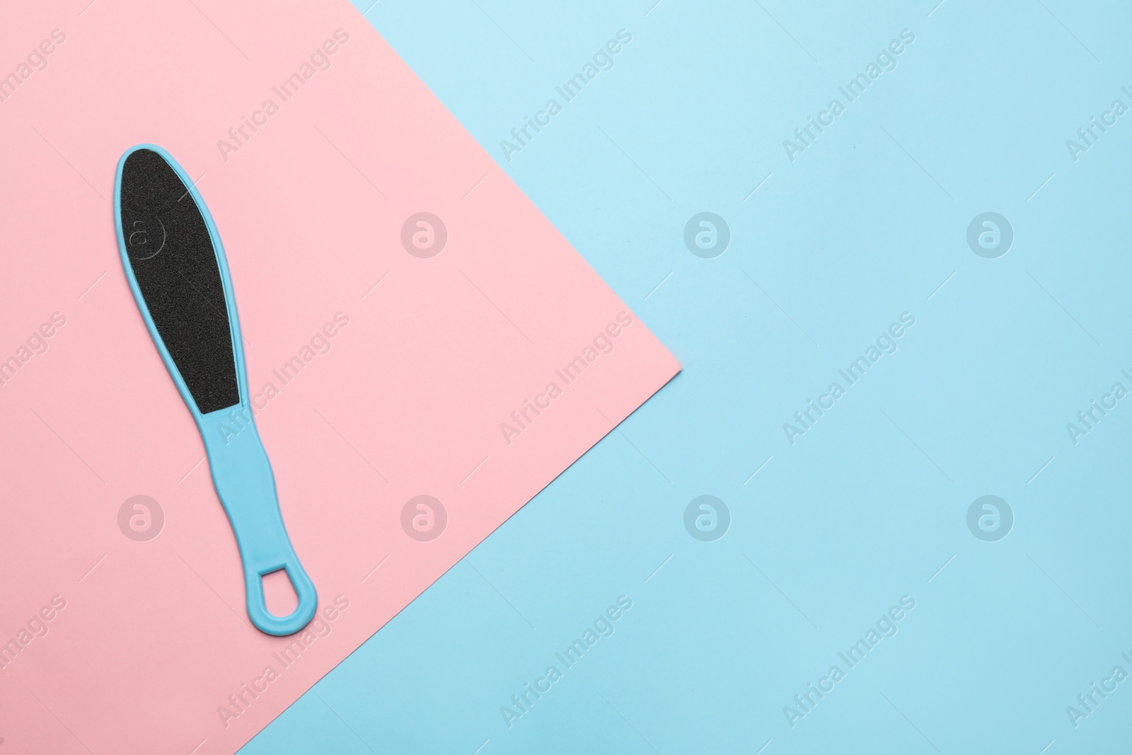 Photo of Foot file on color background, top view with space for text. Pedicure tool