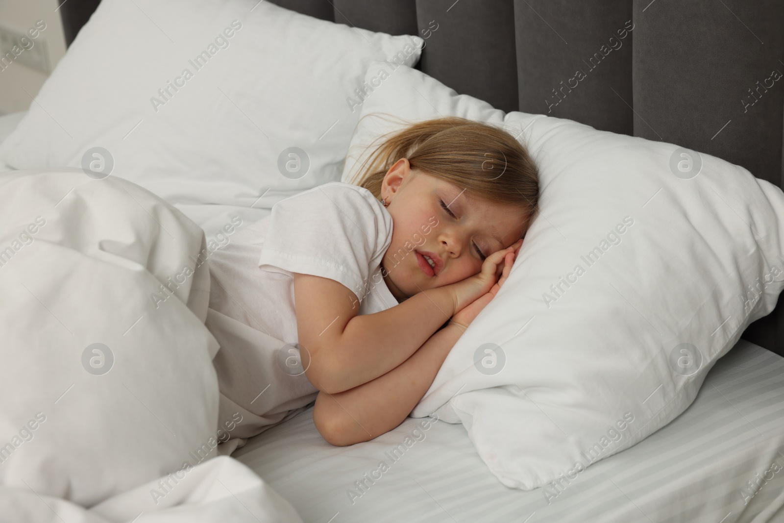 Photo of Little girl snoring while sleeping in bed