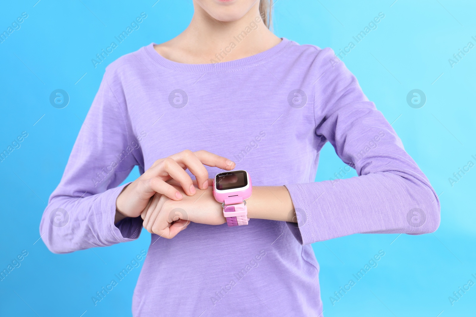 Photo of Girl with stylish smart watch on light blue background, closeup