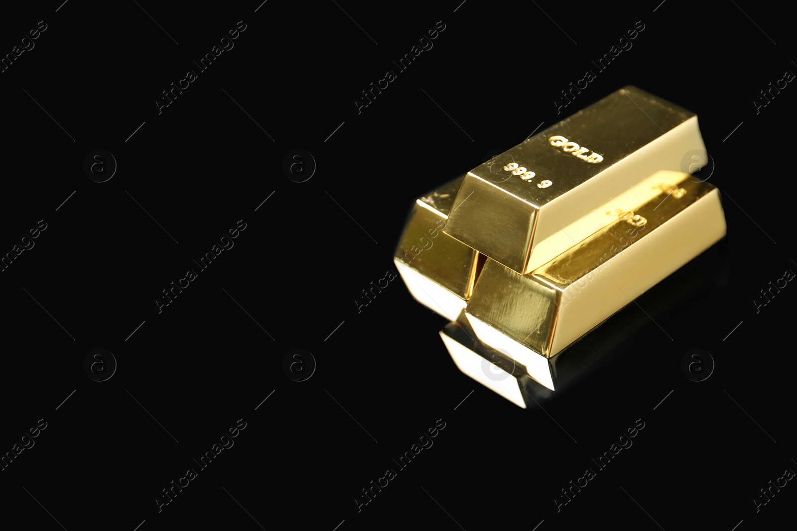 Photo of Shiny gold bars on black background. Space for text