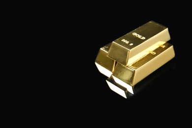 Shiny gold bars on black background. Space for text