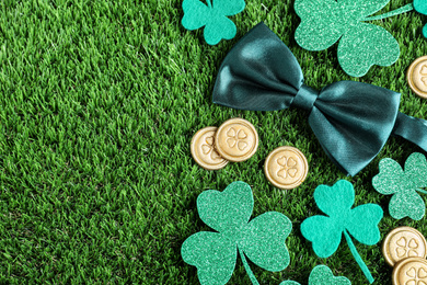 Photo of Flat lay composition with clover leaves on green grass, space for text. St. Patrick's Day celebration