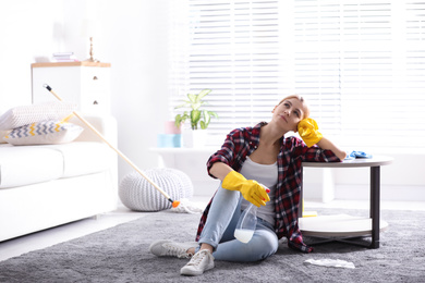 Photo of Lazy young woman wiping table at home. Cleaning and housework