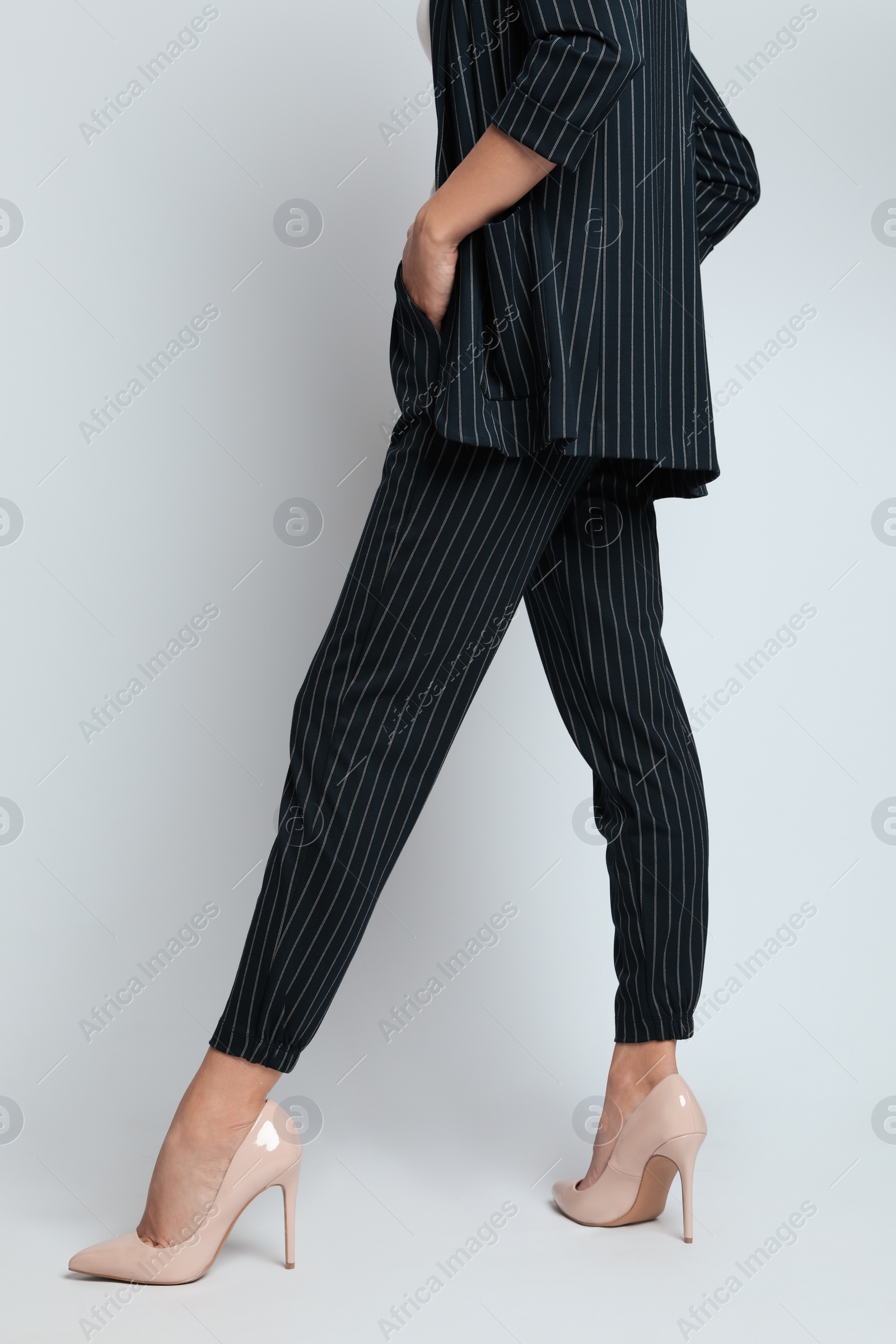 Photo of Woman in formal suit on light background, closeup. Business attire