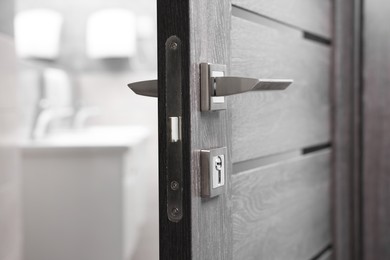 Open wooden door with metal handle, closeup