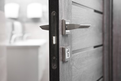 Photo of Open wooden door with metal handle, closeup