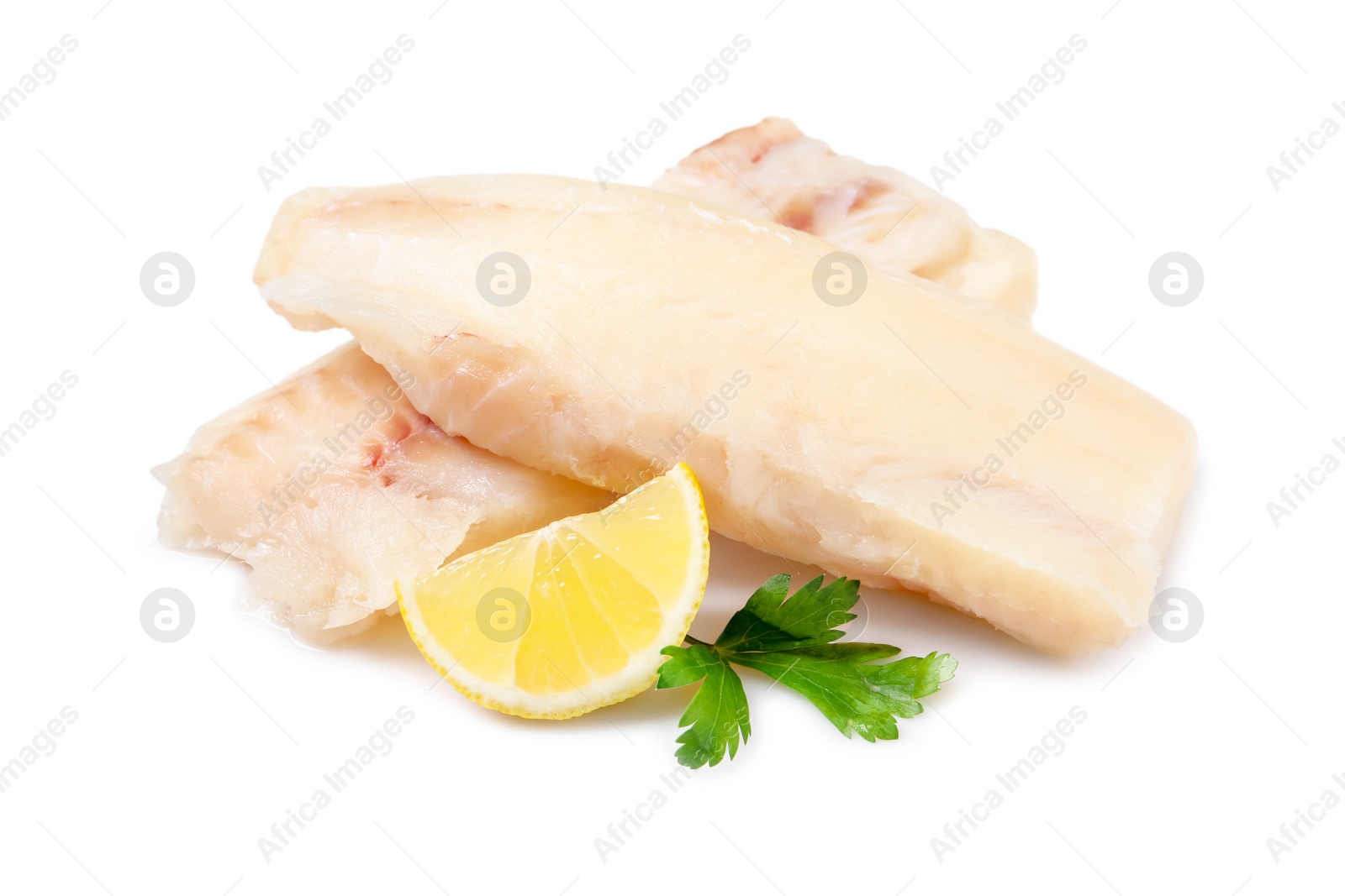 Photo of Pieces of raw cod fish, parsley and lemon isolated on white