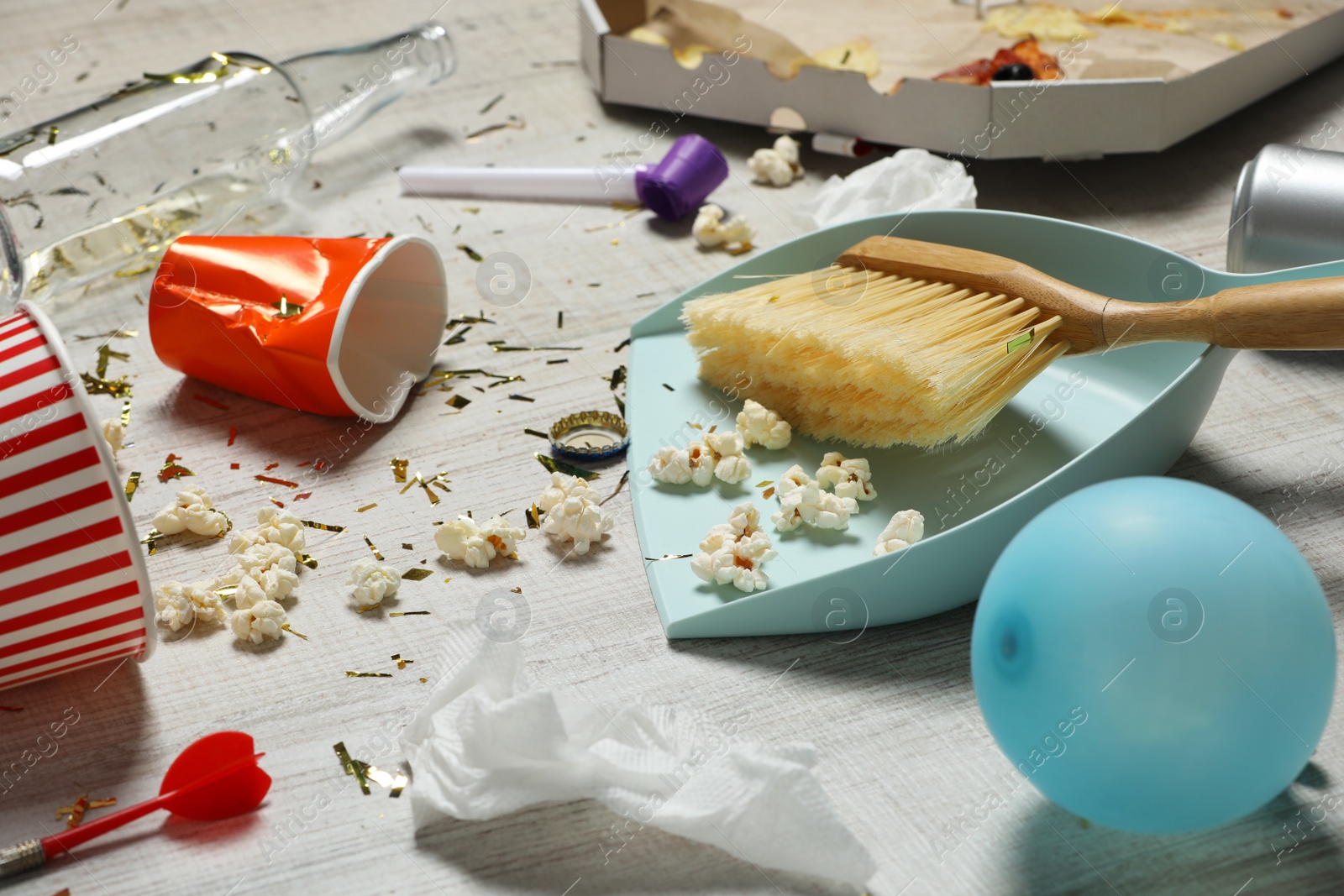 Photo of Brush and dustpan on messy floor after party indoors