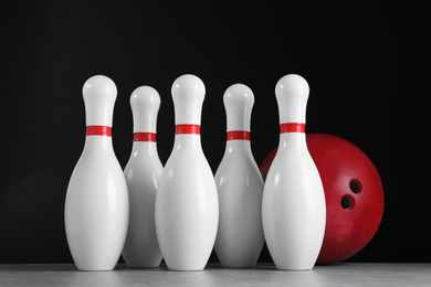 Photo of Red bowling ball and pins on grey stone table