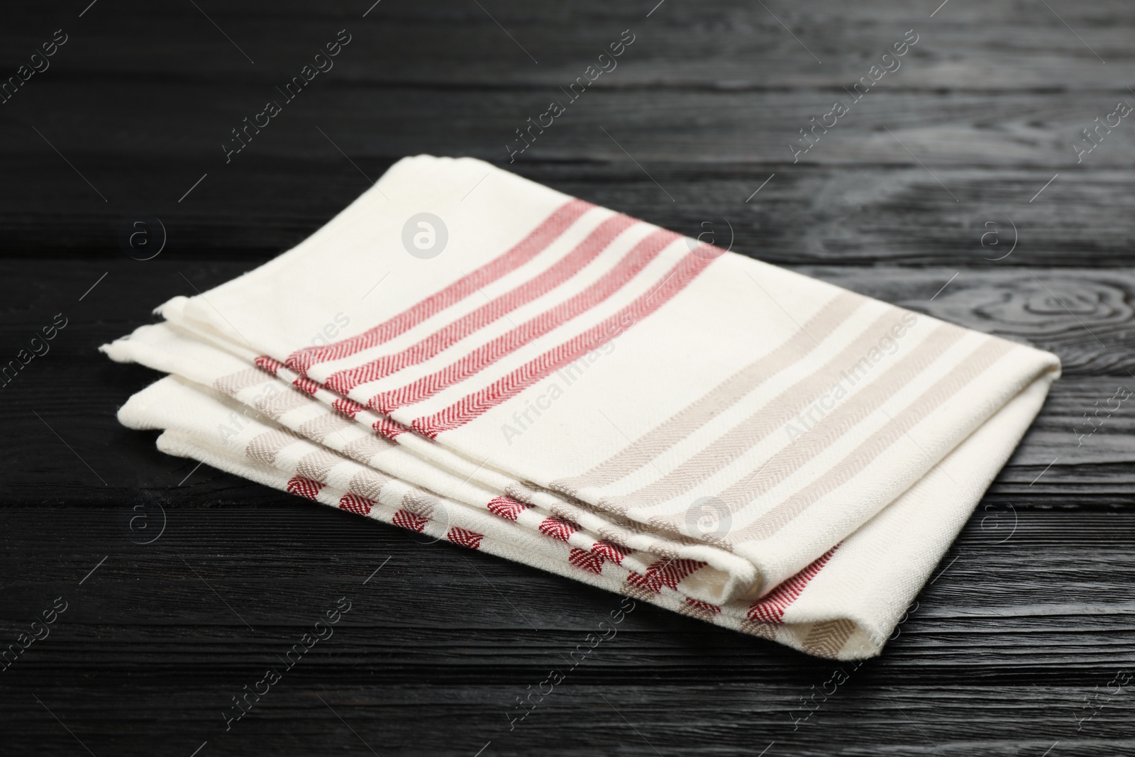 Photo of Striped kitchen towel on black wooden table