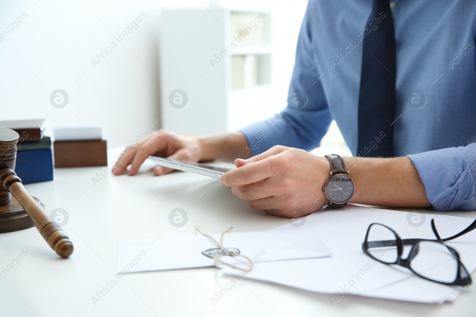 Photo of Notary working with tablet at table in office, closeup. Law and justice concept