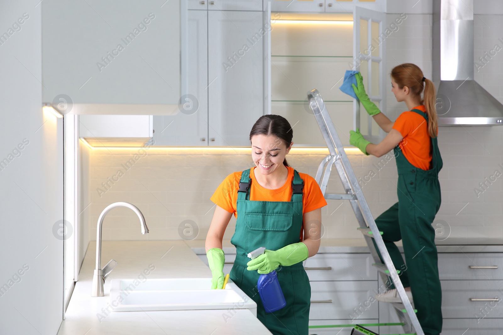 Photo of Team of professional janitors cleaning modern kitchen