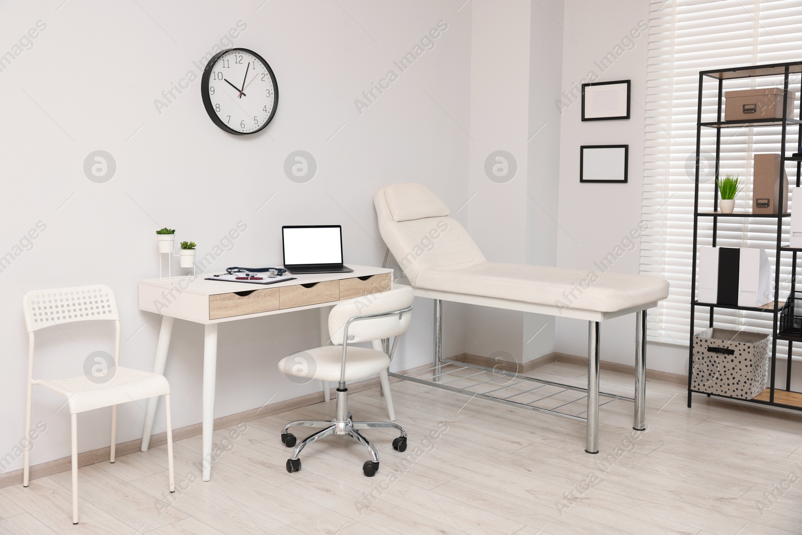 Photo of Modern medical office with doctor's workplace and examination table in clinic