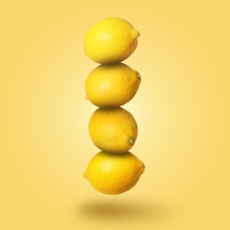 Image of Whole fresh ripe lemons falling on gold background