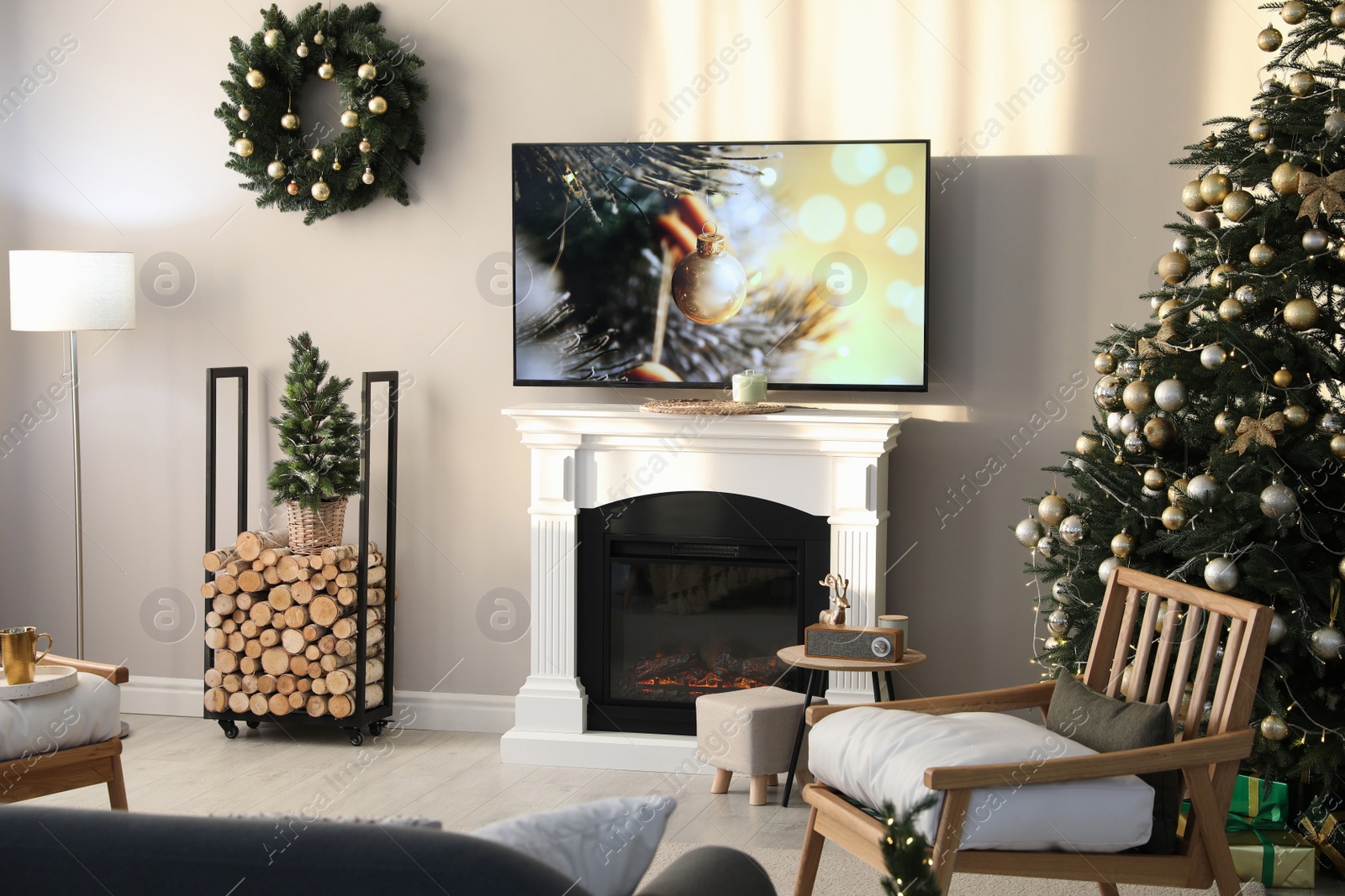 Photo of Modern TV set on light wall in room decorated for Christmas