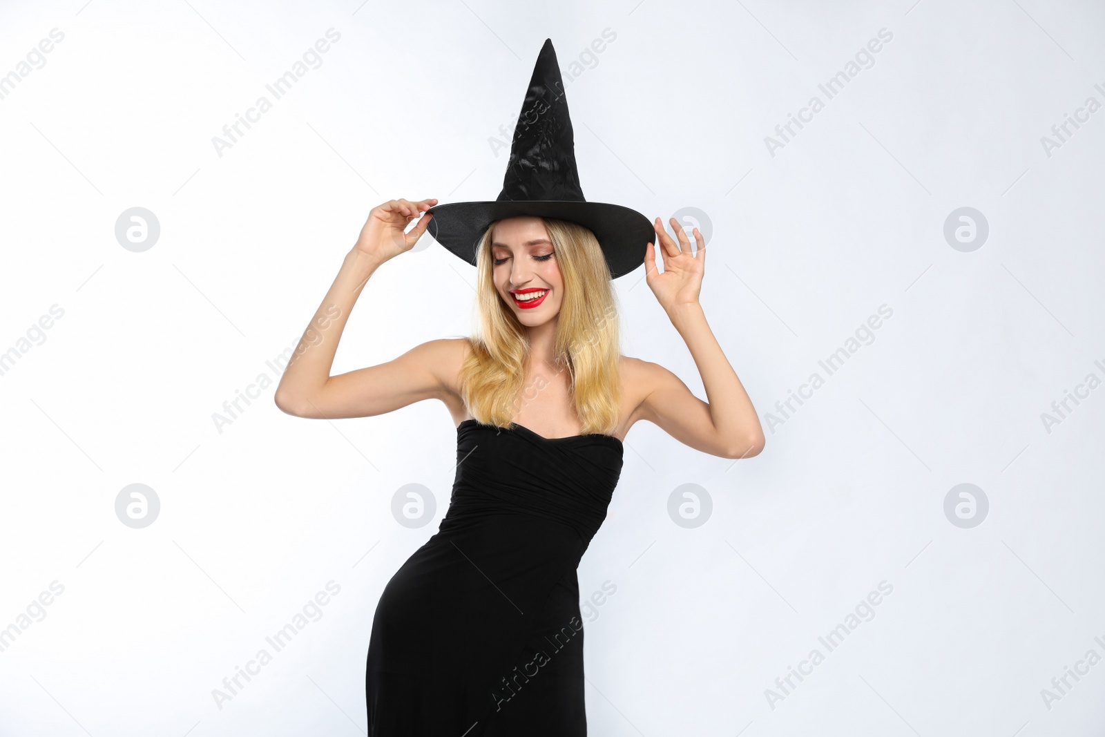 Photo of Beautiful woman in witch costume on white background. Halloween party