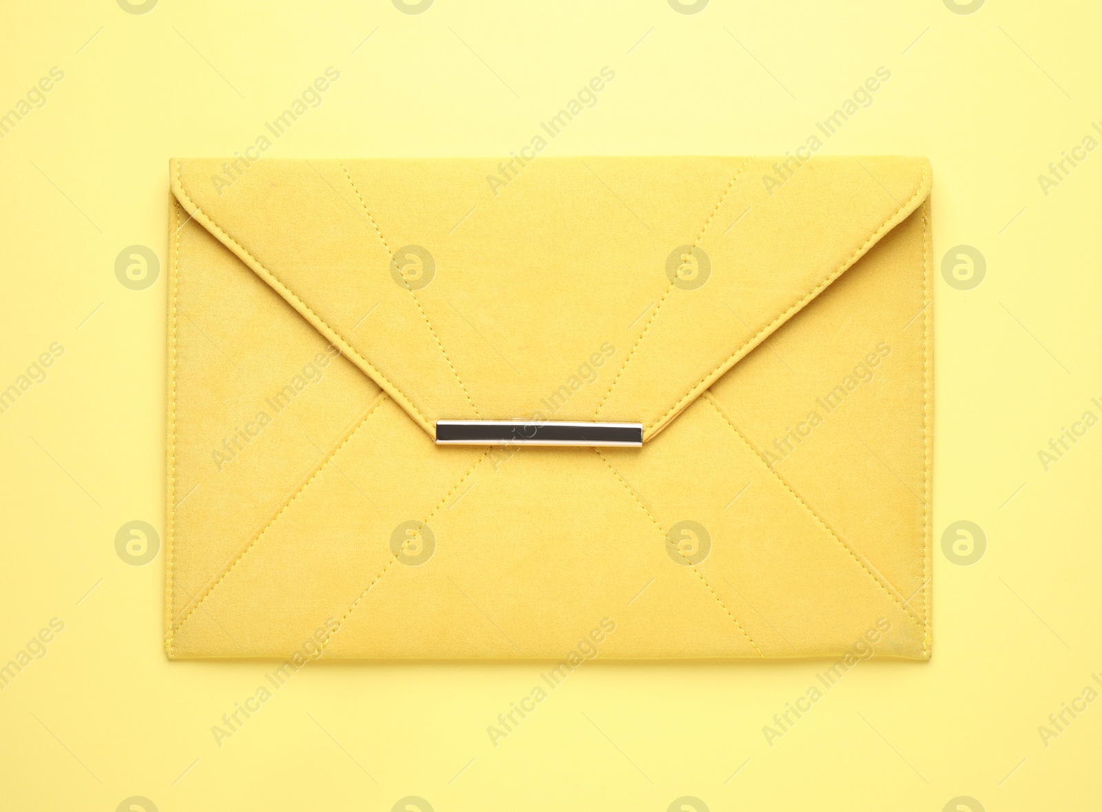 Photo of Stylish woman's bag on yellow background, top view