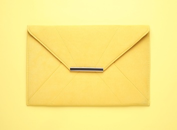 Stylish woman's bag on yellow background, top view