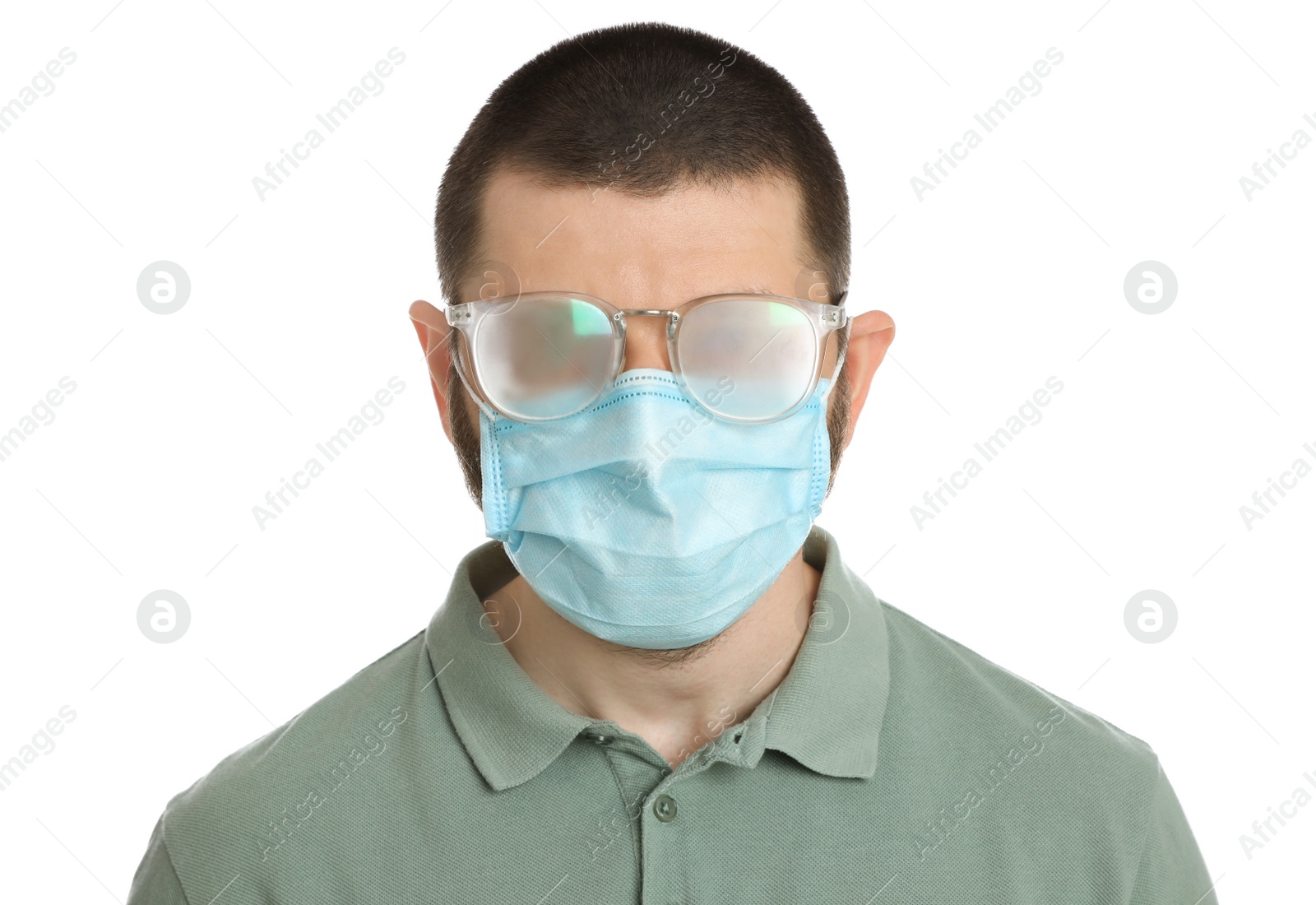 Photo of Man with foggy glasses caused by wearing disposable mask on white background. Protective measure during coronavirus pandemic