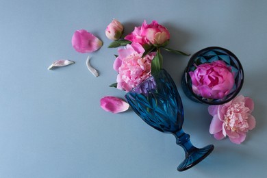 Photo of Flat lay composition with wineglasses and beautiful pink peonies on grey background