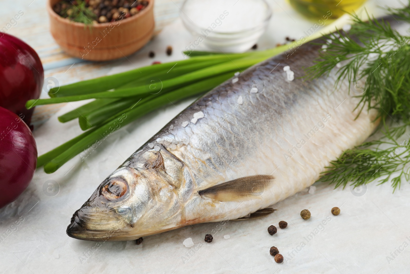 Photo of Delicious salted herring and ingredients on wooden table, closeup