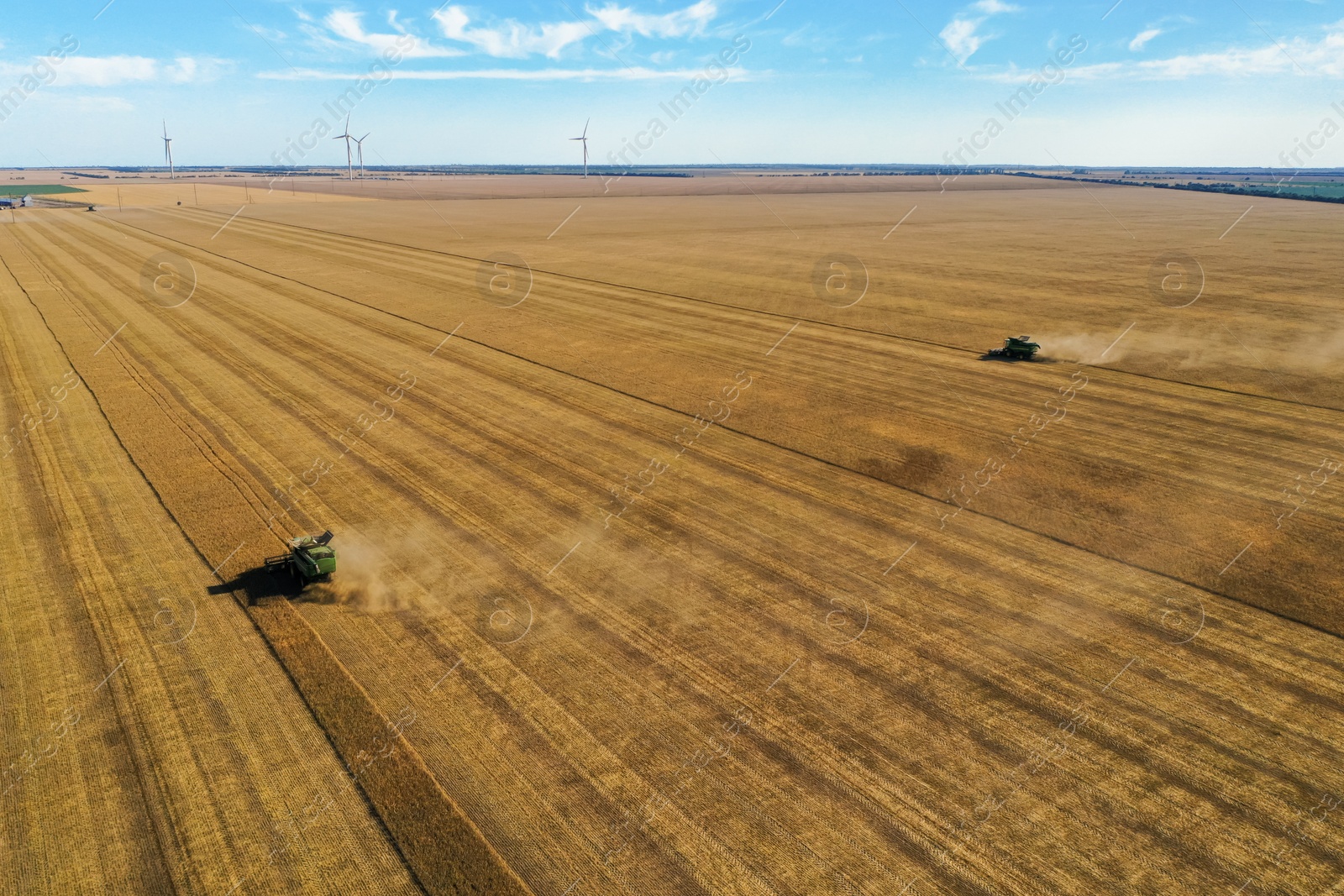 Photo of Beautiful aerial view of modern combine harvester working in field on sunny day. Agriculture industry