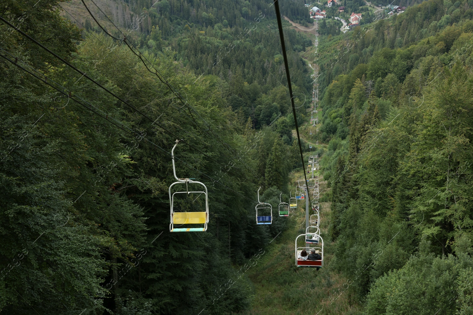 Photo of Ski lift and green trees at mountain resort