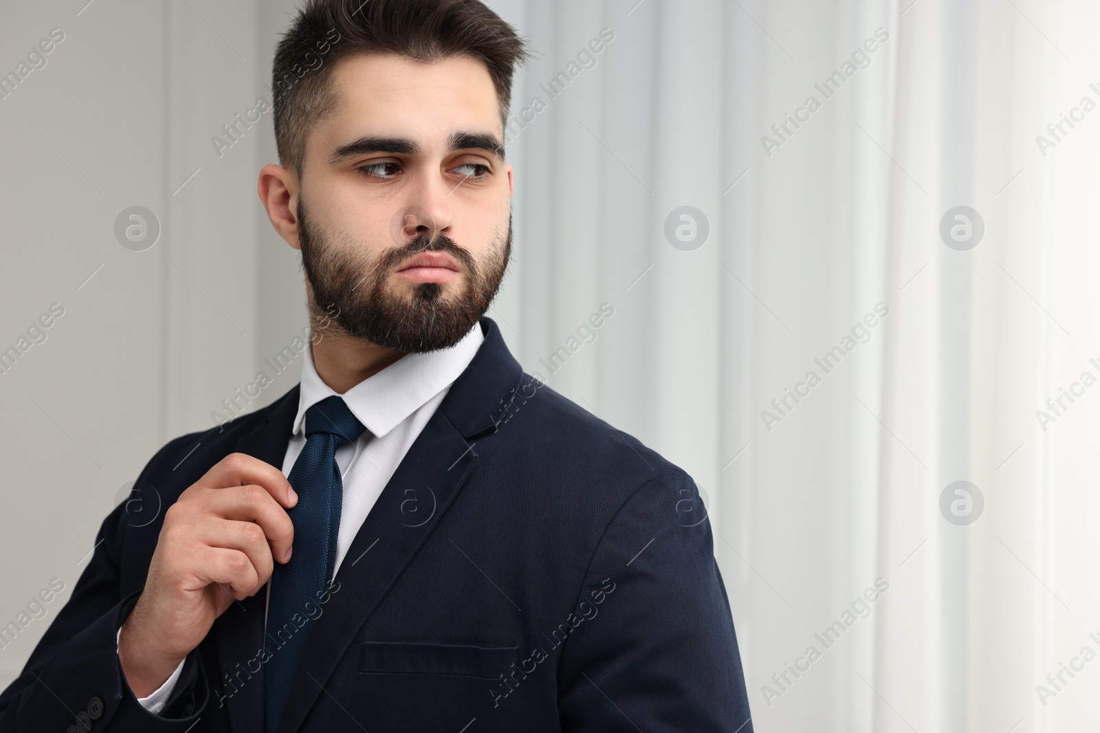Photo of Handsome businessman in suit and necktie indoors. Space for text