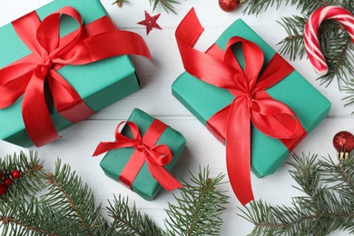 Flat lay composition with gift boxes and Christmas decorations on white wooden table