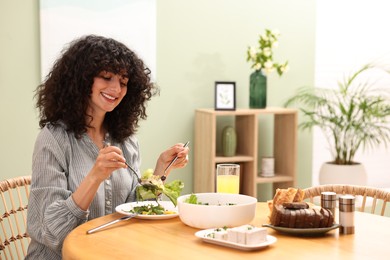 Photo of Woman having vegetarian meal at table in cafe