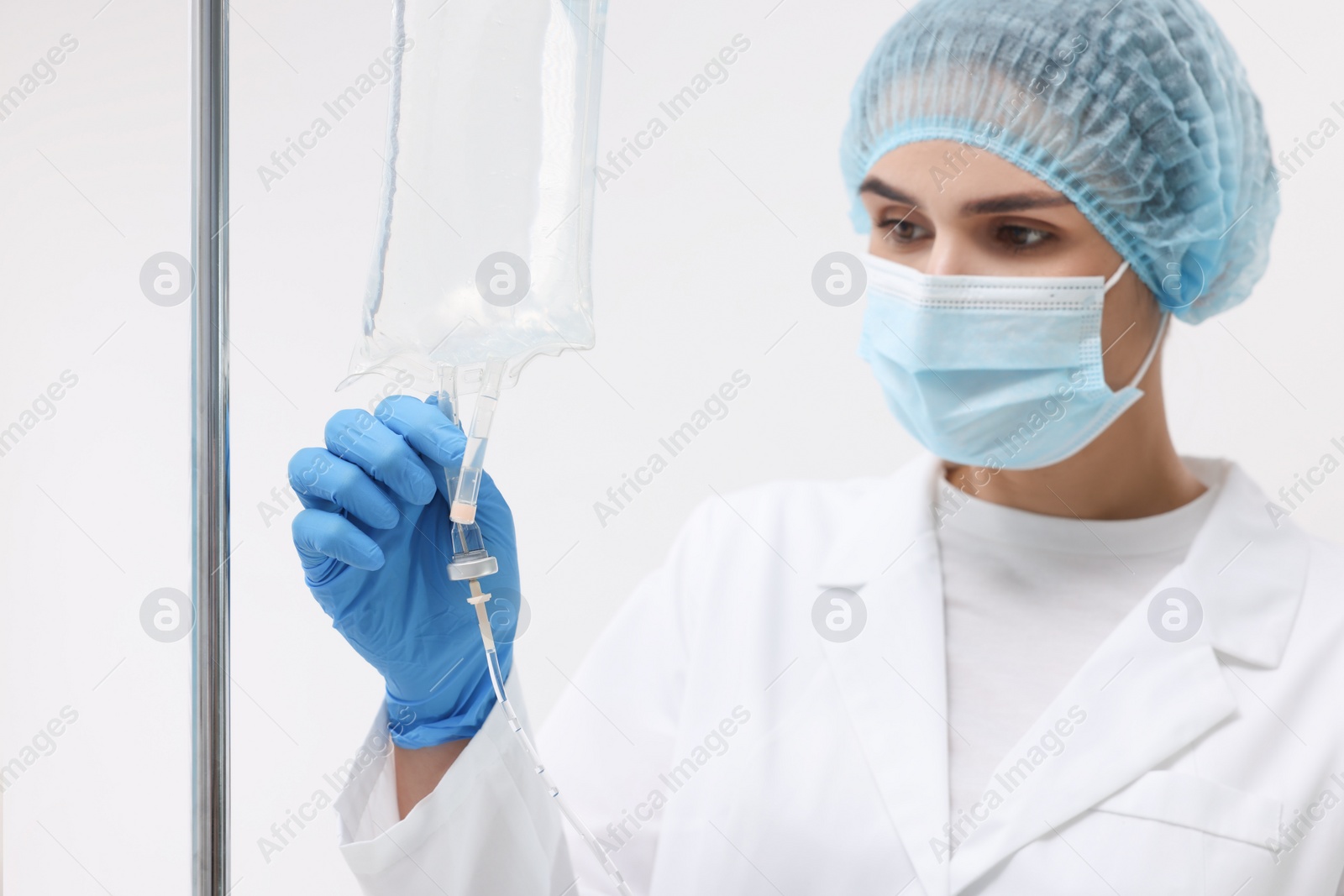 Photo of Nurse setting up IV drip in hospital, selective focus