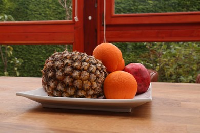 Delicious fresh fruits on wooden table indoors