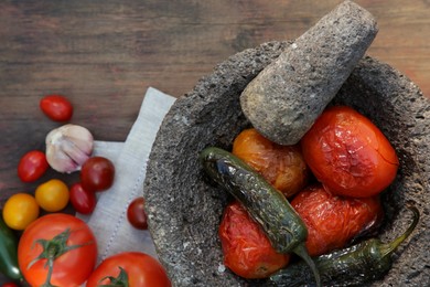Ingredients for tasty salsa sauce, pestle and mortar on wooden table, flat lay