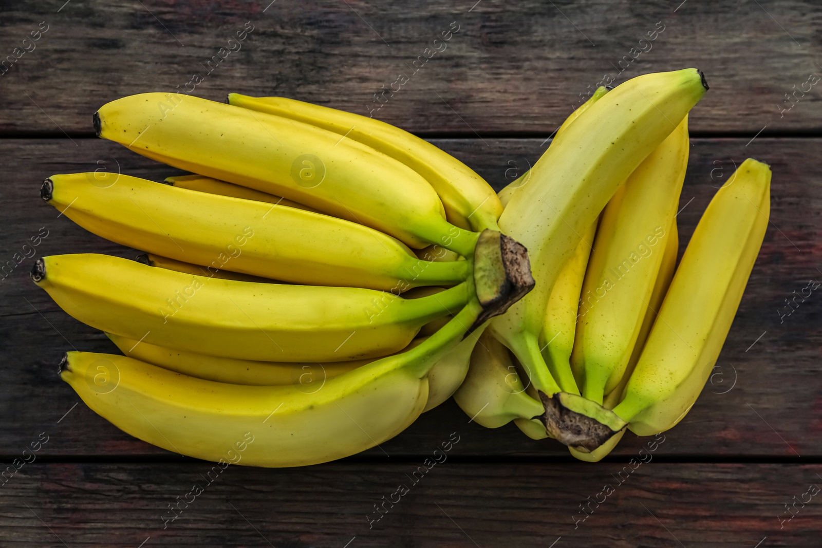 Photo of Ripe yellow bananas on wooden table, flat lay