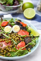 Plate of salad with mung beans on white marble table, closeup