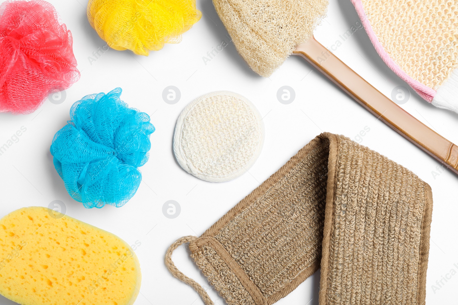 Photo of Plastic and natural shower sponges on white background, top view. Recycling concept