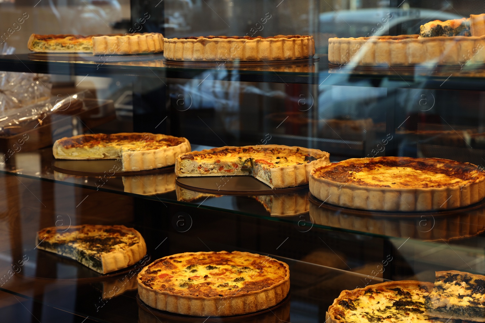 Photo of Different delicious quiches on counter in bakery shop