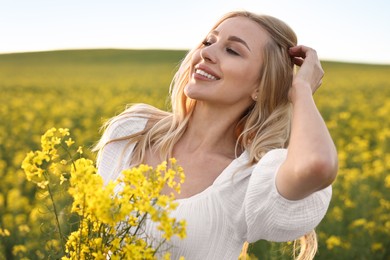 Portrait of happy young woman in field on spring day