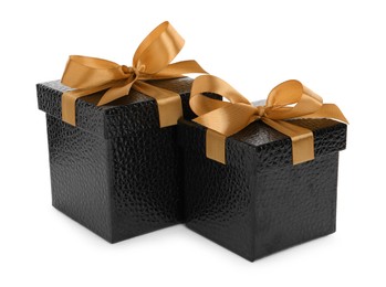 Photo of Black gift boxes with golden bows on white background