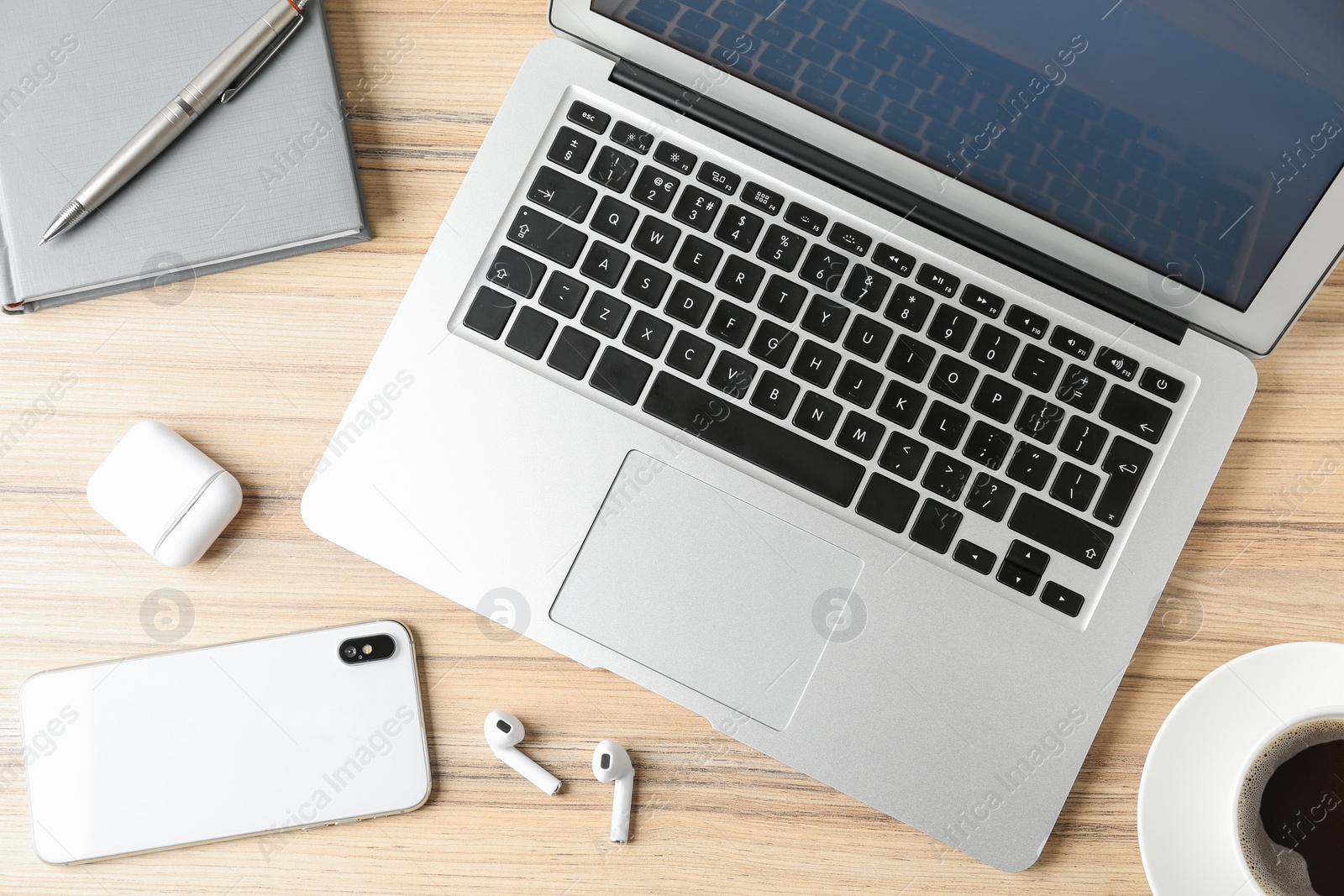 Photo of Flat lay composition with earphones and laptop on wooden table