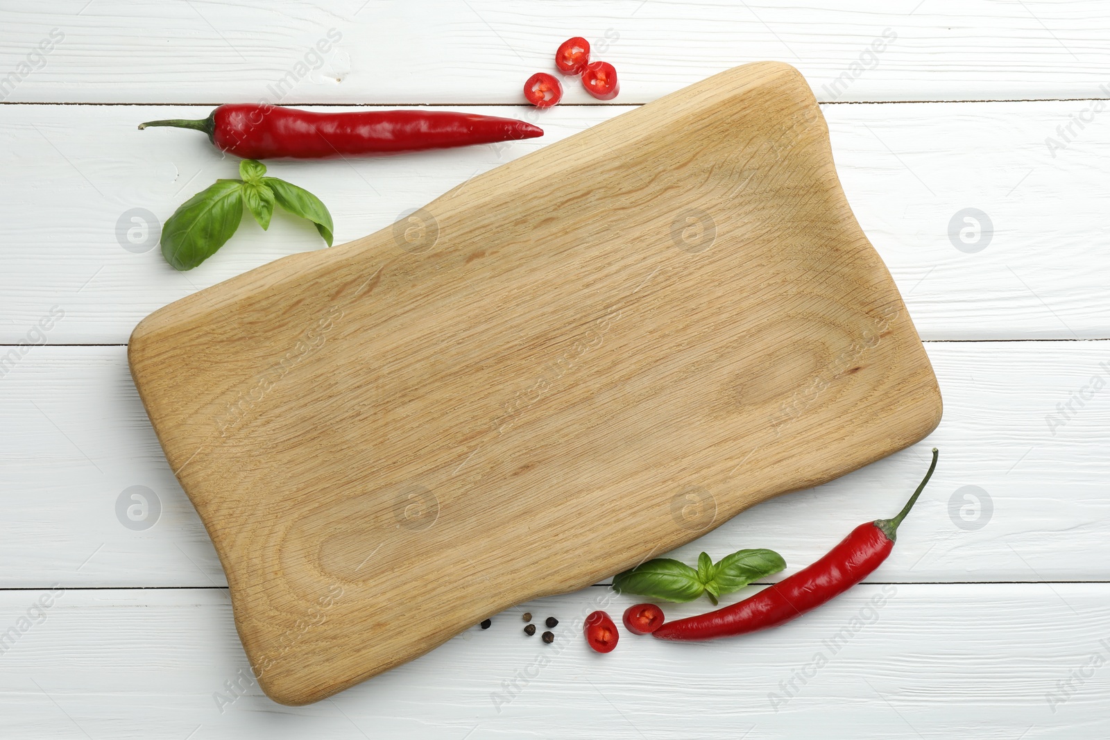 Photo of Cutting board and different spices on white wooden table, flat lay