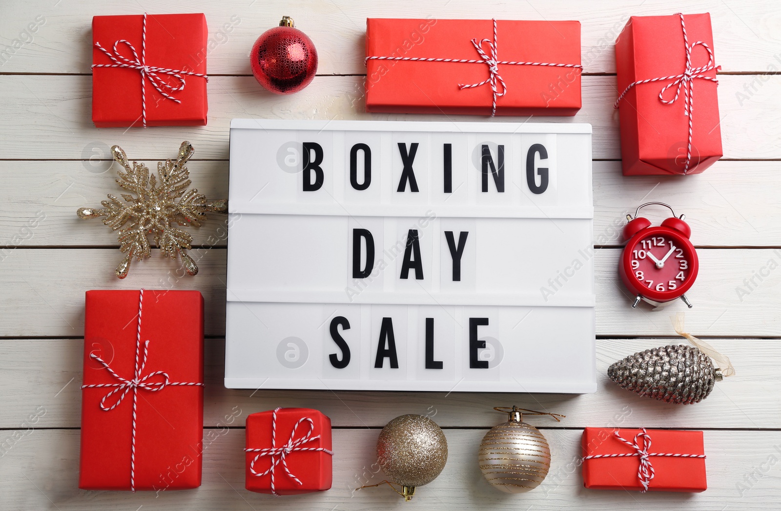 Photo of Flat lay composition with Boxing Day Sale sign and Christmas gifts on white wooden table