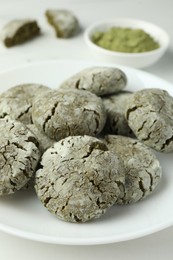 Plate with tasty matcha cookies on white table, closeup