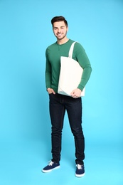 Photo of Full length portrait of young man with eco bag on blue background
