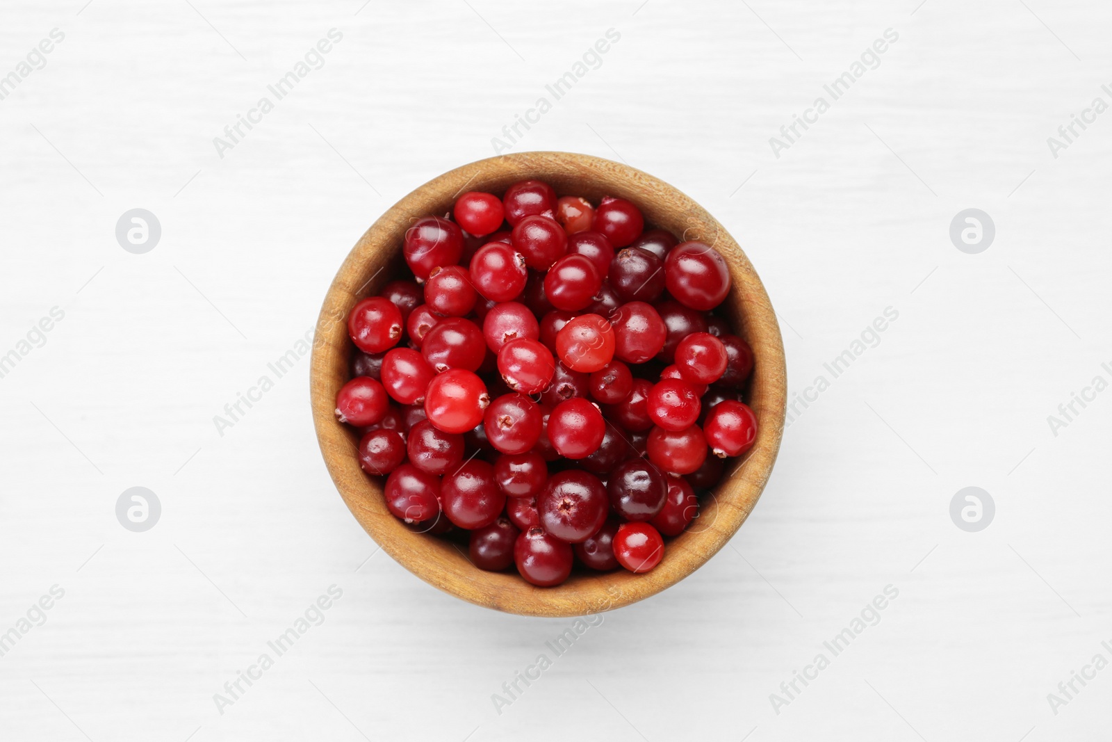 Photo of Fresh ripe cranberries in bowl on white table, top view