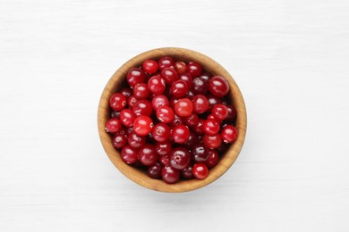 Photo of Fresh ripe cranberries in bowl on white table, top view